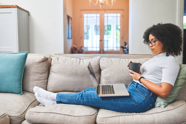 Woman on couch looking at laptop