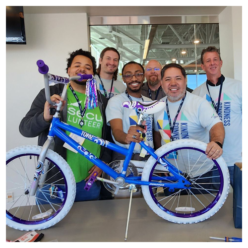 SECU employees holding a bike that they built