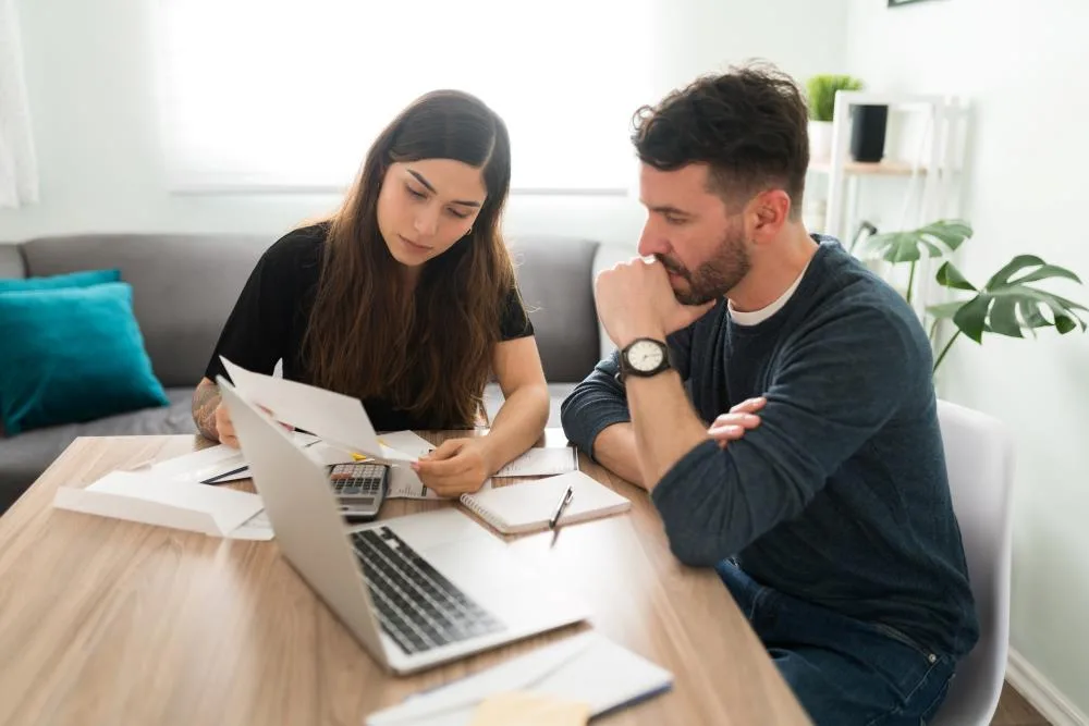 young couple looks at financial documents at a table