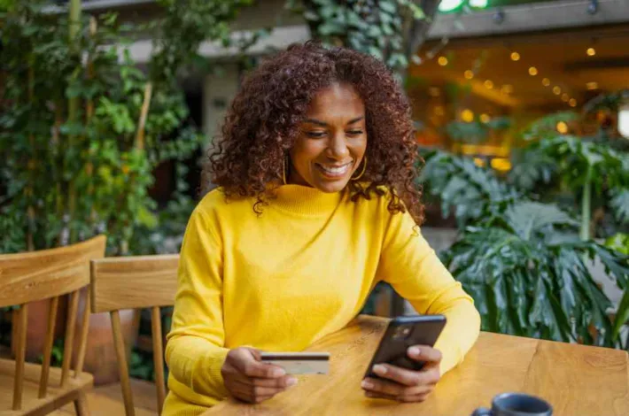 Young woman outdoors online shopping with mobile phone