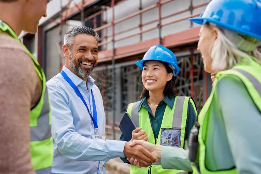 Construction foreman shakes hands with his crew
