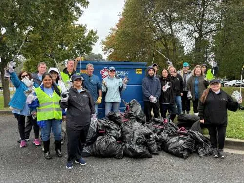 Group of people posing with trash bags after a clean up and collection effort