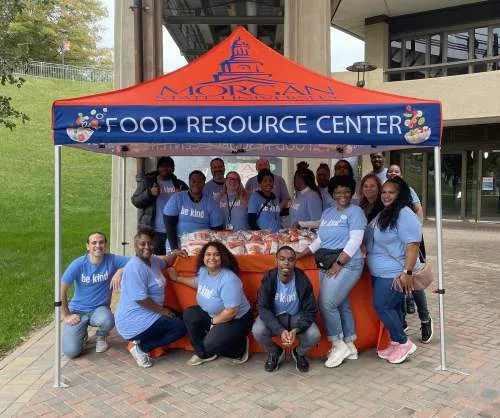 Team of people posing for group photo under a Morgan State Food Resource Center tent