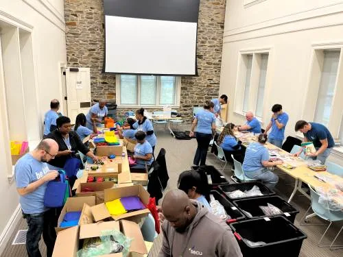 Volunteers inside a building sorting books into containers