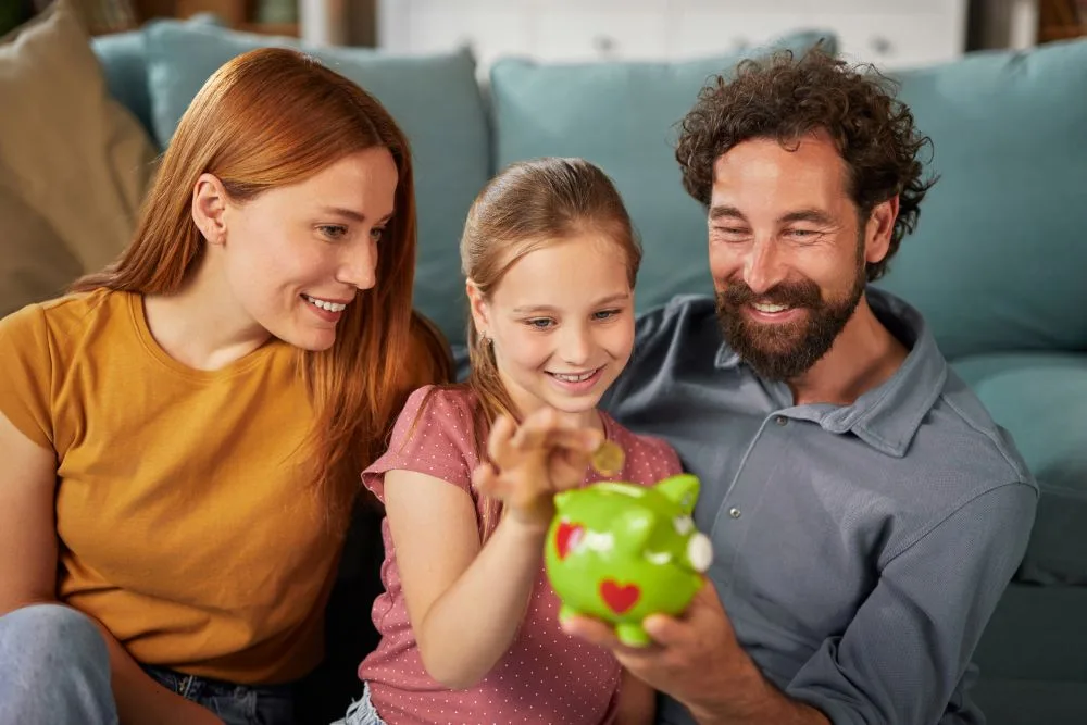 Family saving money together with piggy bank at home