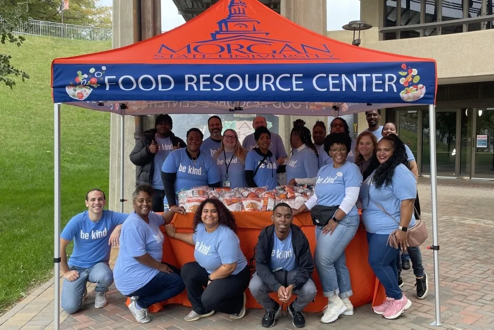 Team of people posing for group photo under a Morgan State Food Resource Center tent