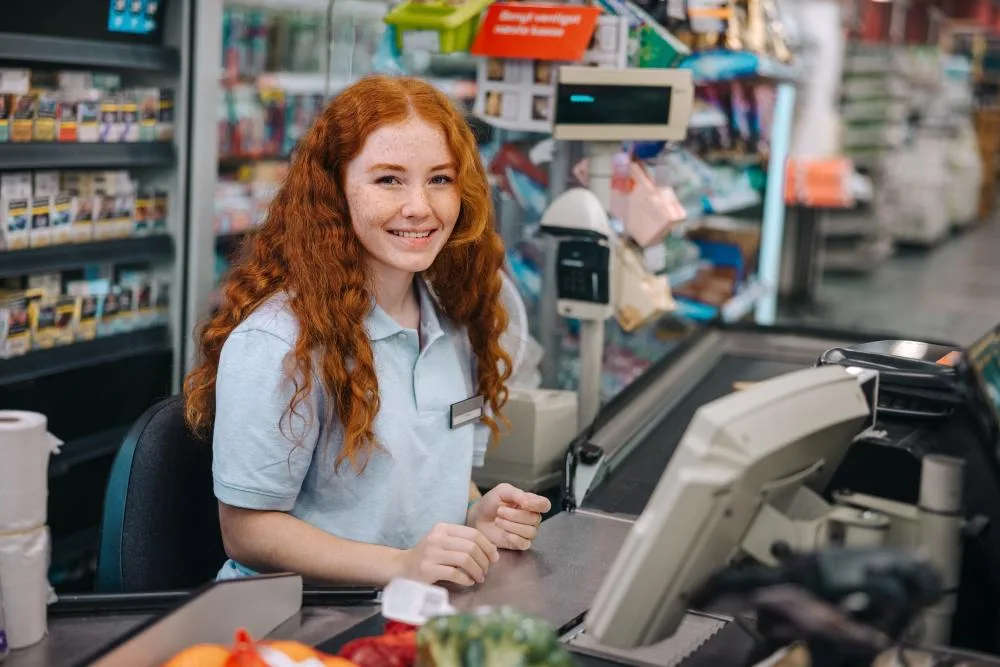 Teen girl working as grocery store cashier