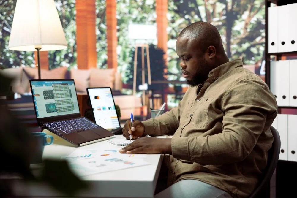 Man sits at desk working on financial paperwork