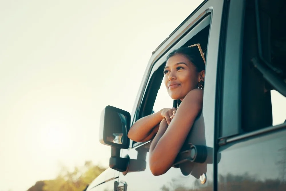 Woman leans out driver's window of a Jeep