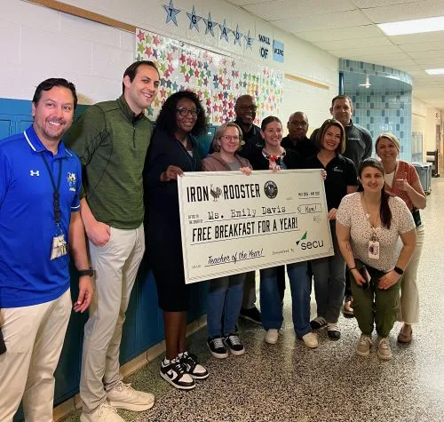 Group poses with Teacher Appreciation winner holding her novelty oversized check