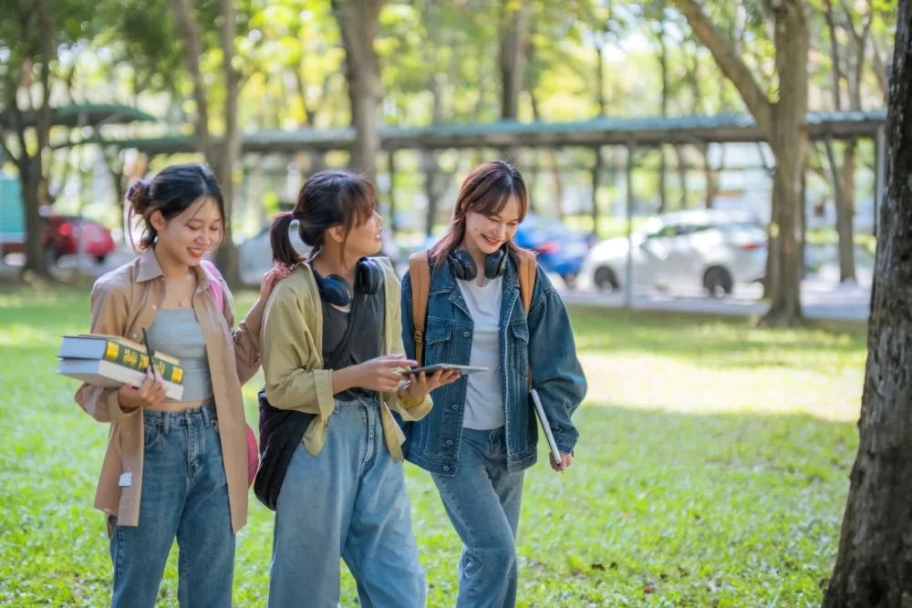 Thee college-age women walk together