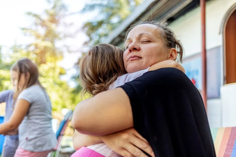 Woman hugs her daughter