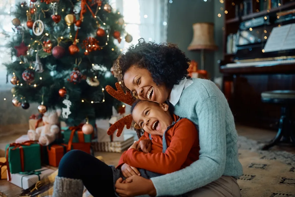 Mother and daughter having fun in front of Christmas tree